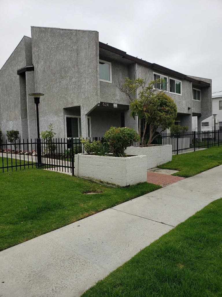 a house with a sidewalk and a black fence